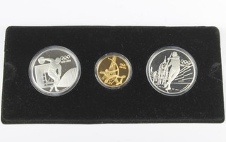 A Olympic Centennial coin set comprising a 22ct 16.97 gram coin - The Archer, 2 Sterling silver coins 33.63 grams each - The Discus Thrower and The Javelin Thrower 