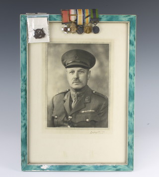 A miniature group of medals comprising Distinguished Service Order, 1914 Star with bar, War medal, Victory and India General Service medal with North Western Frontier 1930-31 bar together with a cap badge and framed photo of the recipient 