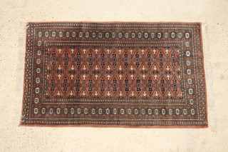 A terracotta ground Bokhara rug with all over geometric design within multi row border 155cm x 95cm 