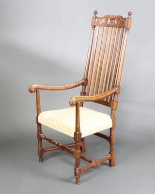 A 19th Century oak carved stick and rail back open armchair with upholstered seat, raised on turned and block supports  