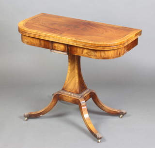 A Regency inlaid and crossbanded D shaped mahogany card table raised on a tapered chamfered column and splayed supports ending in brass paw feet 78cm x 91cm x 46cm d  