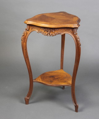 A Victorian carved walnut shield shaped 2 tier occasional table with quarter veneered and crossbanded top, the apron heavily carved, 70cm x 44cm x 44cm 