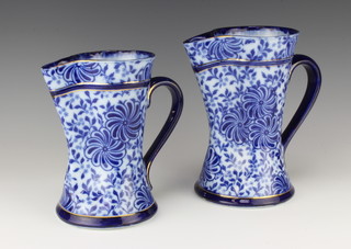 Two Doulton Burslem Flo Bleu pattern pinched and waisted jugs 22cm and 19cm 