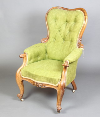 A Victorian carved rosewood show frame armchair upholstered in green material, the seat of serpentine outline raised on cabriole supports