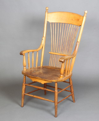 A 19th Century elm stick and rail back kitchen carver chair with solid seat and box framed stretcher 