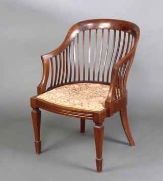 A Victorian mahogany stick and tub back chair with upholstered seat raised on square tapered supports ending in spade feet (1 spindle is f and r) 