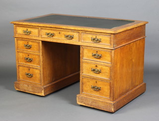 An Edwardian light oak desk with inset leather writing surface fitted 1 long and 8 short drawers 72cm h x 123cm w x 70cm d 