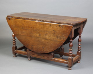 An 18th Century oval oak drop flap gateleg dining table raised on turned and block supports 70cm h x 132cm w x 47cm when closed x 144cm when open 