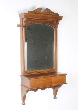 A Victorian arched plate hall mirror contained in a carved walnut frame, the base fitted a rectangular box enclosed by a hinged lid 75cm x 35cm x 16cm 