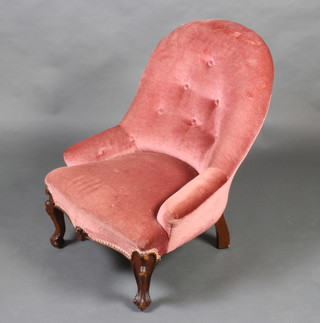A Victorian tub back nursing chair upholstered in rose pink velvet, raised on cabriole supports 