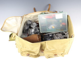 A large canvas and leather tackle bag containing a Condex centre pin fishing reel, a Gear Fly fishing reel, a Shakespeare 040 reel, an Okuma reel etc 
