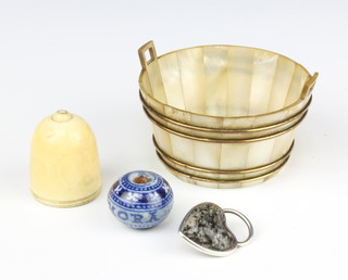 A blue and white bead marked RVIT HORA together with an acorn shaped carved section of ivory 3cm, a white metal hardstone pendant in the form of a heart and a mother of pearl and gilt banded twin handled butter dish 3cm x 4cm 
 