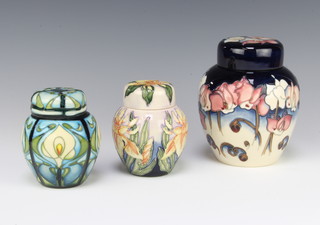 A contemporary Moorcroft ginger jar and cover decorated with flowers dated 2001 15cm, a ditto 11cm and another 11cm dated 2001, 2 boxed 
