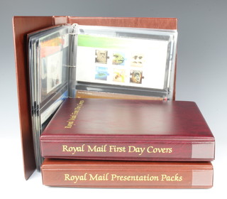 Three albums of Elizabeth II mint presentation stamps and first day covers 