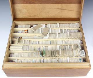 A wooden box containing a large collection of Wills cigarette cards and Brooke Bond tea cards 