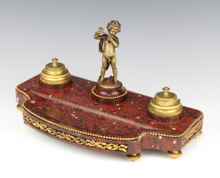 A 19th Century French shaped red marble twin bottle standish with gilt metal bead work border, pen receptacle and an associated bronze seal in the form of a standing boy, raised on bun feet 19cm x 35cm x 18cm 