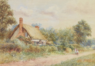 An Edwardian watercolour, indistinctly signed, a West Country rural scene with figures before a thatched cottage 25cm x 34cm 