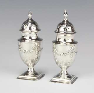 A pair of Victorian repousse silver pepperettes with floral swags, Sheffield 1892, 11cm, 140 grams