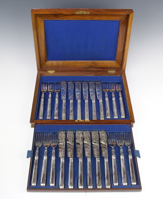 A cased set of 12 Victorian silver fish eaters with chased floral decoration and monograms, filled handles London 1879, maker George W Adams 