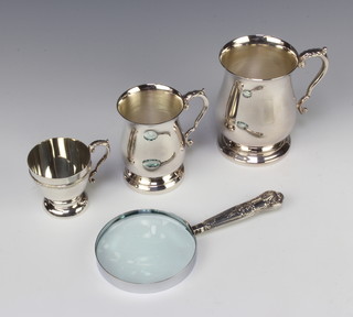 A silver handled magnifying glass and 3 plated mugs 