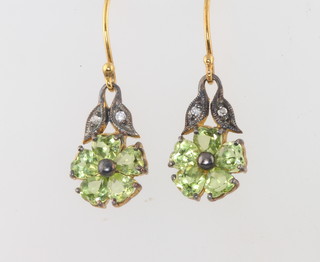A pair of Edwardian style drop floral earrings set with diamonds and peridot 
