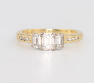 An 18ct yellow gold baguette cut diamond ring with diamond shoulders, size L 