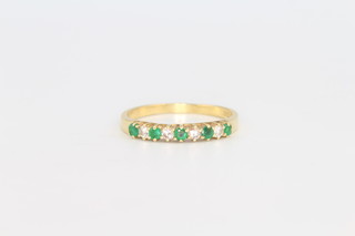 An 18ct yellow gold emerald and diamond half eternity ring size P, gross weight 2.5 grams