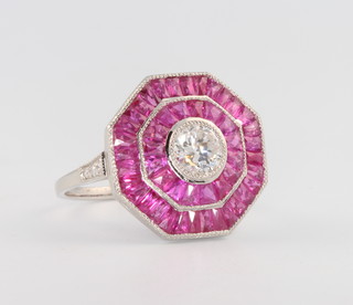 A platinum octagonal cluster ring set with rubies and diamonds the centre diamond approximately 0.50 carat size N 1/2