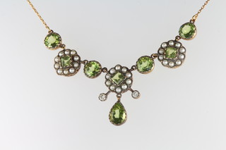 An Edwardian style necklace set with diamonds, seed pearls and peridot on a 9ct yellow gold chain