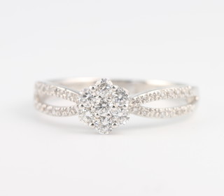 An 18ct white gold diamond daisy ring size O 