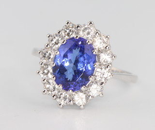 An 18ct white gold tanzanite and diamond oval cluster ring, the centre stone 2.8ct surrounded by brilliant cut diamonds, approx. 1.3ct, size P 