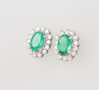 A pair of 18ct white gold oval emerald and diamond ear studs, gross weight 2.7 grams