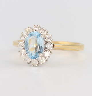 An 18ct yellow gold  aquamarine and diamond ring, the centre stone approx. 1ct, flanked by brilliant cut diamonds, size M 
