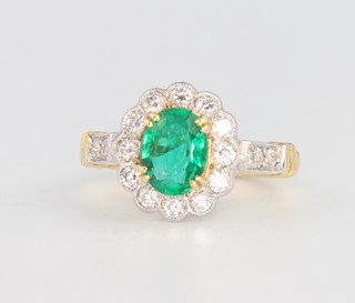 An 18ct yellow gold oval emerald and diamond ring, the centre stone approx. 1.25ct surrounded by brilliant cut diamonds, size M 1/2