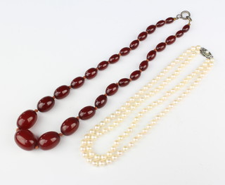 A cultured pearl 2 strand necklace with a silver clasp and a string of red amber beads 