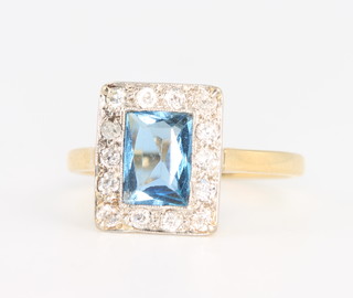 An 18ct yellow gold rectangular cut aquamarine and diamond cluster ring, the centre stone approx. 1ct, size N 