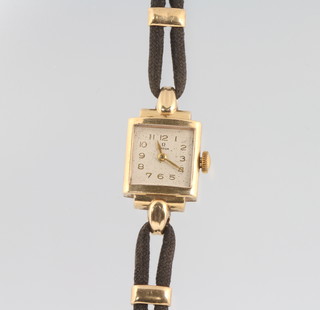 A lady's 9ct yellow gold Omega wristwatch on a silk strap with gold mounts 