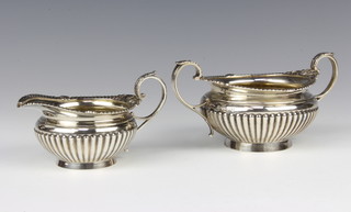 A Victorian repousse silver demi-fluted cream jug and sugar bowl, London 1893, 322 grams 