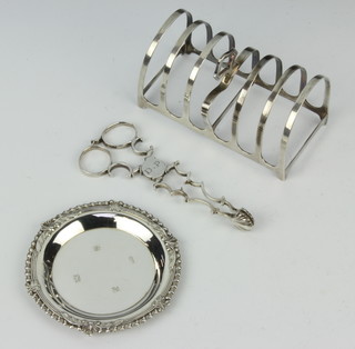 A pair of Georgian silver scissor action sugar nips, a silver nut dish and a silver 7 bar toast rack, 150 grams  