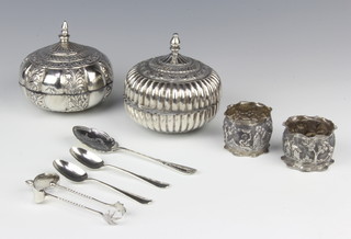 A pair of Victorian silver sugar nips, two silver teaspoons, two plated napkin rings, two plated boxes and covers and a spoon