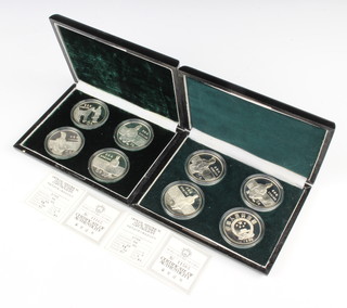 Two cased sets of four silver People's Republic of China commemorative crowns, 176 grams 

