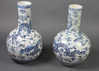 A pair of 18th Century style Chinese blue and white baluster vases with waisted necks decorated with dragons 60cm 