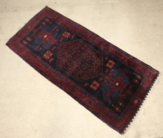 A red and blue ground Persian Koliai carpet with central medallion and animal decoration 287cm x 131cm 