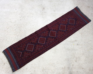 A red and blue ground Meshwani runner with 5 diamonds to the centre within a multi row border 261cm x 64cm 