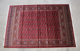 A red and brown ground Bokhara style Belgian cotton carpet with numerous octagons to the centre 230cm x 160cm 