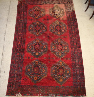 A red ground Afghan carpet with 8 medallions to the centre within a multi row border, signed and dated 364cm x 220cm 