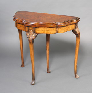 A 1930's figured walnut Queen Anne style card table with shaped top, raised on club supports 73cm h x 80cm w x 40cm d 