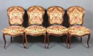 A set of 4 Victorian rosewood show frame dining chairs with upholstered seats and backs raised on cabriole supports (1 ceramic caster is missing) 
