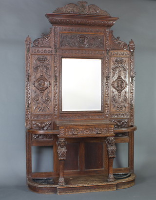 A large and impressive Victorian carved oak hall stand with carved crest to the top,  bevelled plate mirror to the centre and 10 hooks, complete with drip tray (f), 152 cm h x 50cm w 