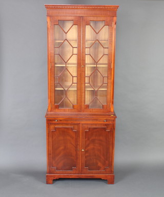 A Georgian style mahogany bookcase on cabinet with moulded and dentil cornice, fitted adjustable shelves enclosed by astragal glazed panelled doors, the base fitted a brushing slide above a panelled door, raised on bracket feet 190cm h x 76cm w x 33cm d 
